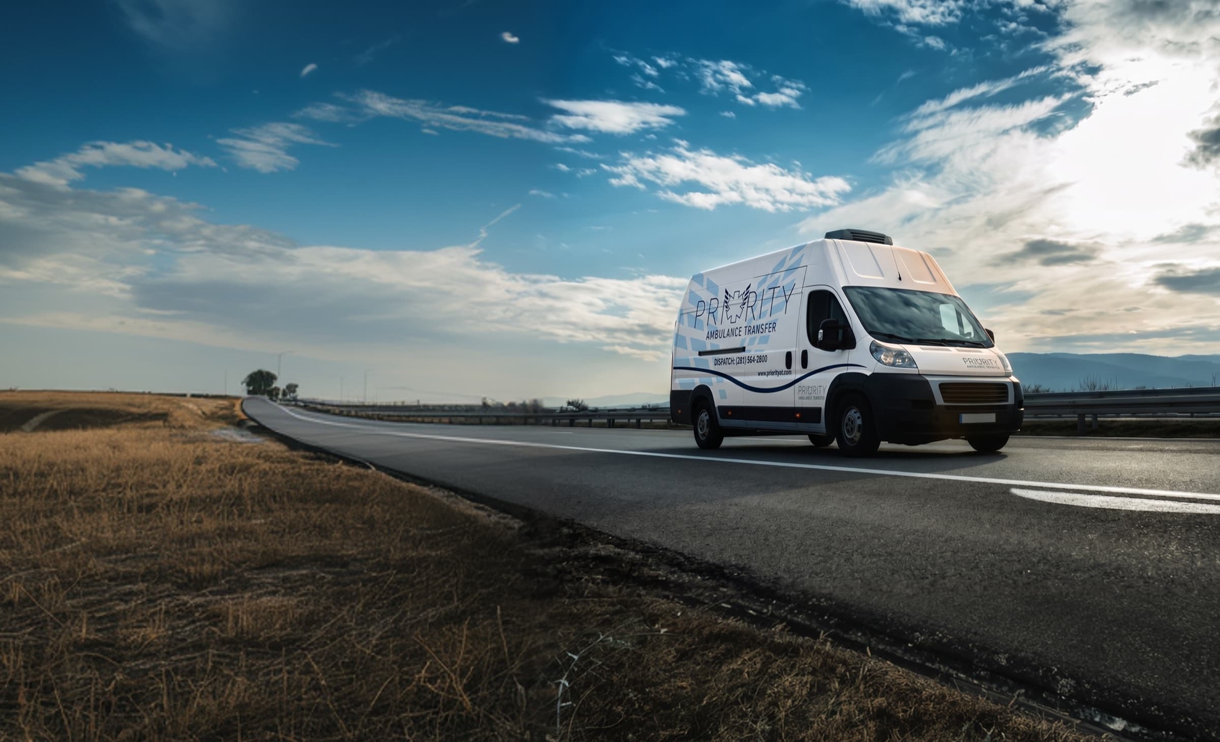 A Priority Ambulance Transfer van on a rural Texas highway.